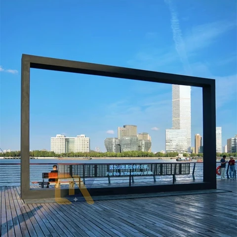 A black giant photo frame on a waterfront deck.