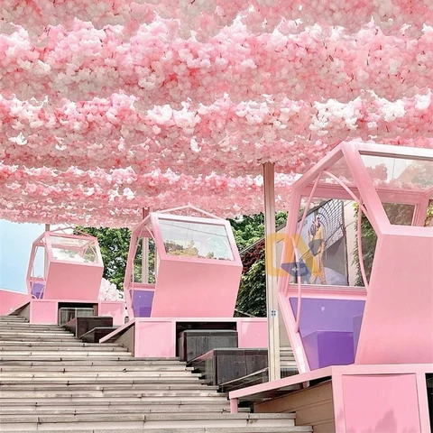 Pink seating booths arranged beside steps under a blossom-themed canopy.